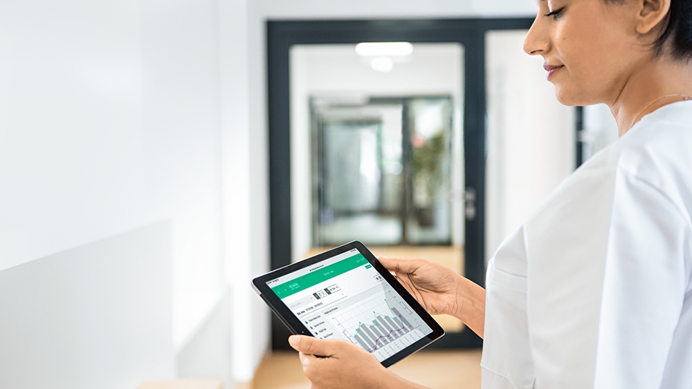Sygeplejerske, der kigger på en nexadia-skærm på en tablet
