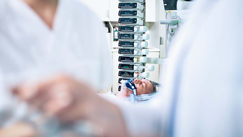 Patienten ligger på en intensivafdeling – der er mange B. Braun infusionspumper i baggrunden