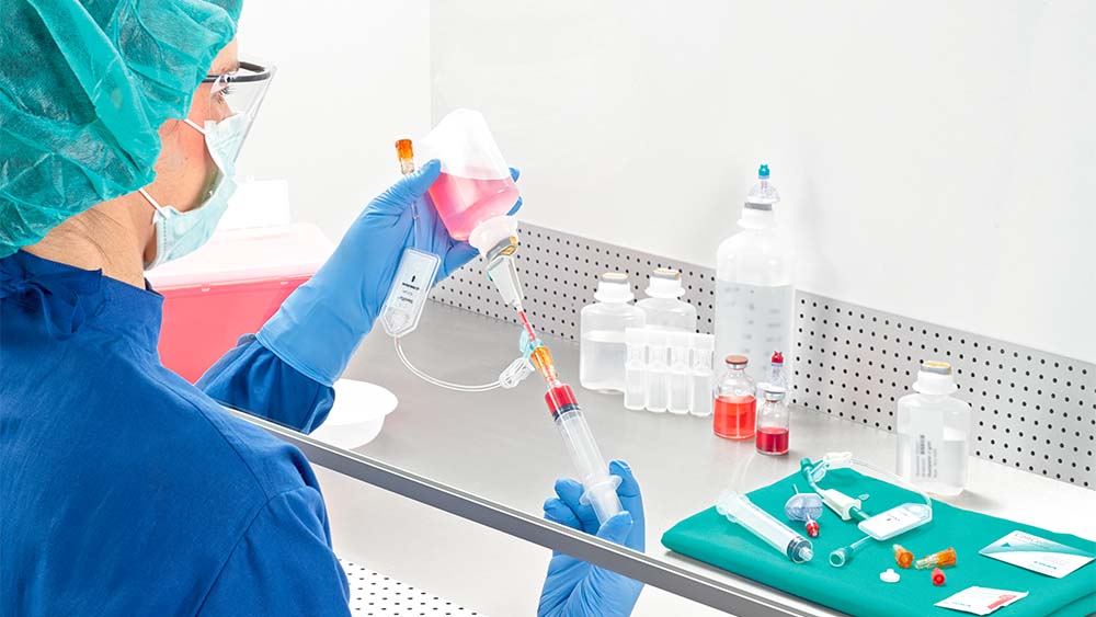 Apoteker trækker sprøjte op under lamina luftstrøm