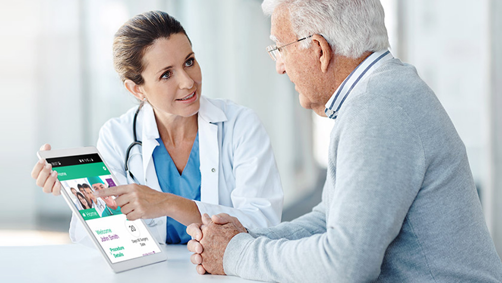 Lægen forklarer patientappen til sin patient på en tablet