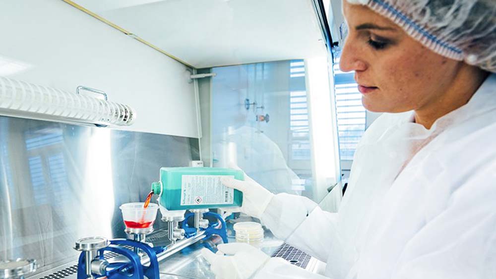 En laboratoriemedarbejder fylder medicinsk udstyr med B. Braun desinfektionsmiddel. 